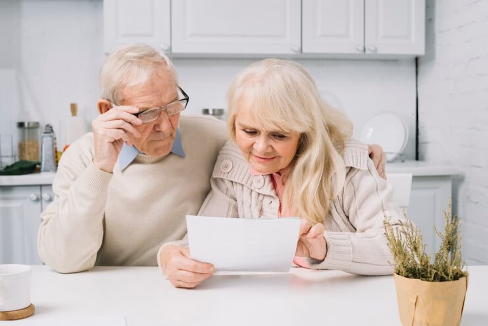 Ancianos leyendo los beneficios de la venta de nuda propiedad